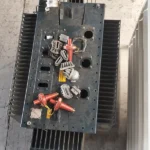 Vista superior de un transformador eléctrico dañado por vandalismo, con sus componentes rotos y dislocados.
